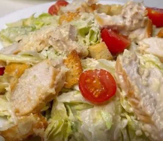 Μεγάλη σαλατιέρα με σαλάτα του Καίσαρα, πλούσια σε σάλτσα, με ψητό κοτόπουλο, κρουτόν και παρμεζάνα.