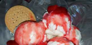 Κόκκινη, γλυκιά σάλτσα φράουλας σε ένα γυάλινο μπολ.