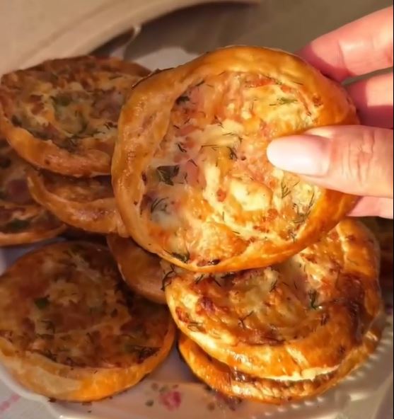 sfoliates me zampon kai tiri2 Χρυσαφένιες, τραγανές σφολιάτες με ορατή γέμιση από λιωμένο τυρί και ζαμπόν, πασπαλισμένες με μυρωδικά.