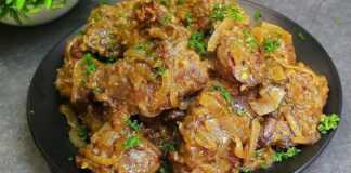 Ένα πιάτο με κομμάτια τηγανισμένου συκωτιού κοτόπουλου ανακατεμένα με σοταρισμένα κρεμμύδια σε ελαφριά σάλτσα.