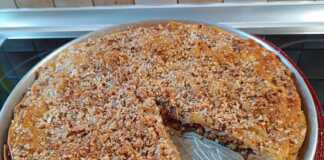 Τάρτα Μπακλαβάς: Ένα απροσδόκητα νόστιμο γλυκό! Τάρτα μπακλαβάς μόλις σιροπιάστηκε, με εμφανείς τις χαραγμένες μερίδες και πασπαλισμένους ξηρούς καρπούς.