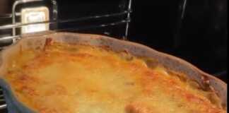 Ένα χρυσαφένιο σουφλέ κοτόπουλο με μανιτάρια σε ένα ταψί, πασπαλισμένο με λιωμένο τυρί.