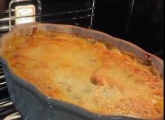 Ένα χρυσαφένιο σουφλέ κοτόπουλο με μανιτάρια σε ένα ταψί, πασπαλισμένο με λιωμένο τυρί.