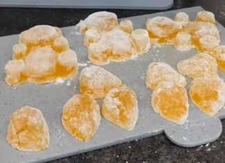 Ένα μπολ γεμάτο σπιτικά ζελεδάκια πορτοκάλι σε διάφορα σχήματα.