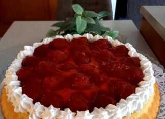 Μια στρογγυλή τάρτα φράουλας με χρυσαφένιο παντεσπάνι, στρώση λευκής σαντιγί, φρέσκες κόκκινες φράουλες τοποθετημένες κυκλικά και γυαλιστερό κόκκινο ζελέ από πάνω.