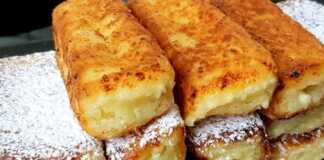 Χρυσαφένιες τυροκροκέτες πασπαλισμένες με άχνη σε ένα πιάτο.