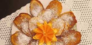 Στοίβα από χρυσαφένιες τηγανίτες πορτοκάλι, γαρνιρισμένες με φέτες πορτοκαλιού ή σιρόπι.