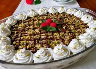 Ένα γυάλινο μπολ γεμάτο με στρώσεις από σαβαγιάρ, κρέμα φυστικιού, νουτέλα και γαρνιρισμένο με ψιλοκομμένα φυστίκια.