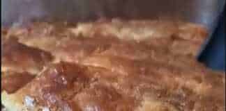 Λαχταριστή τυρόπιτα με σόδα κομμένη σε κομμάτια σε ξύλινο δίσκο.