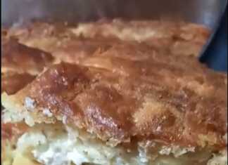 Λαχταριστή τυρόπιτα με σόδα κομμένη σε κομμάτια σε ξύλινο δίσκο.