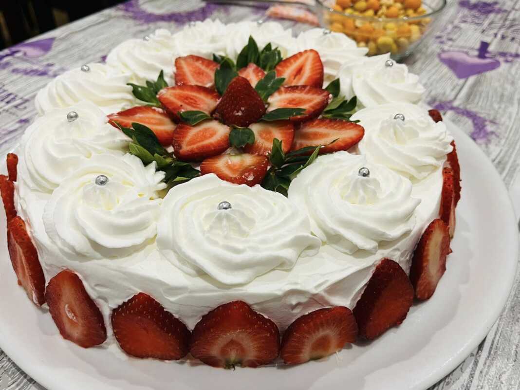 torta fraoula Μια ολόκληρη, όμορφα διακοσμημένη τούρτα φράουλα, με φρέσκες φράουλες και κρέμα, έτοιμη για σερβίρισμα.