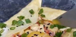 Ένα λαχταριστό πρωινό αυγό-τορτίγια με ρευστό κρόκο στο κέντρο, γεμιστό με λουκάνικο, ντομάτα και τυρί.