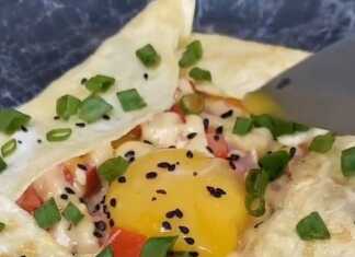 Εντυπωσιακό Πρωινό Αυγό-Τορτίγια Ένα λαχταριστό πρωινό αυγό-τορτίγια με ρευστό κρόκο στο κέντρο, γεμιστό με λουκάνικο, ντομάτα και τυρί.