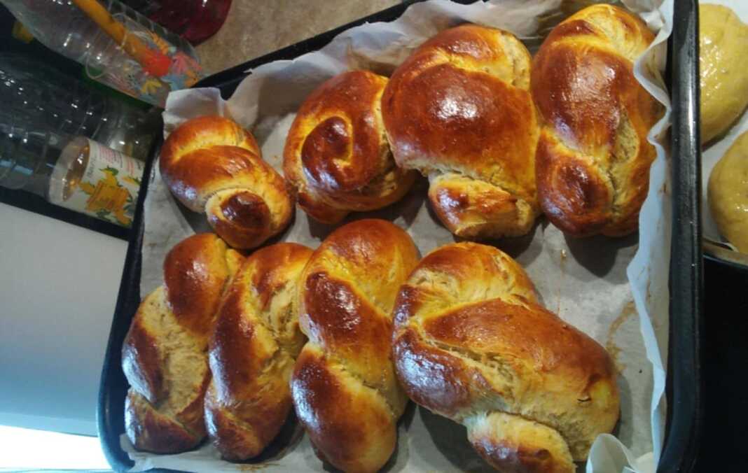 Φωτογραφία με φρεσκοψημένα, χρυσαφένια τσουρεκάκια σε ταψί.