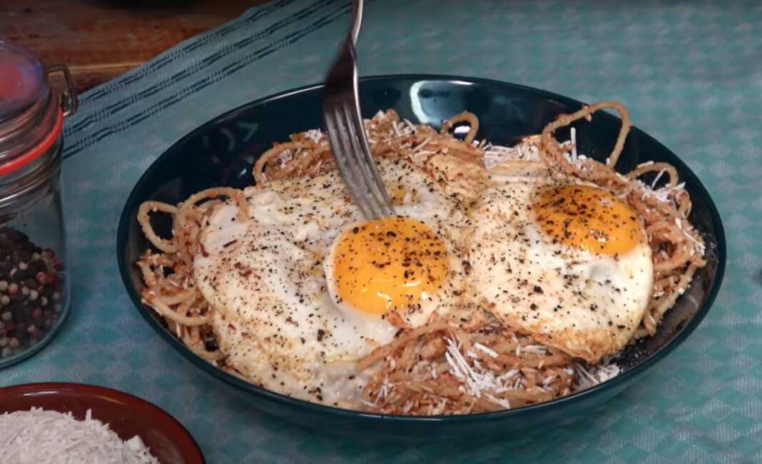 Φωτογραφία με μακαρόνια τσουχτή σερβιρισμένα με τριμμένη μυζήθρα και τηγανητά αυγά.