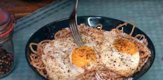 Φωτογραφία με μακαρόνια τσουχτή σερβιρισμένα με τριμμένη μυζήθρα και τηγανητά αυγά.