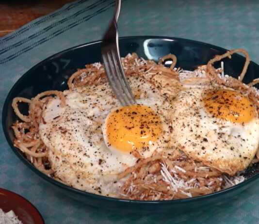 Φωτογραφία με μακαρόνια τσουχτή σερβιρισμένα με τριμμένη μυζήθρα και τηγανητά αυγά.