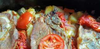 Χοιρινές μπριζόλες στην γάστρα με πατάτες, καρότα και μελιτζάνες, έτοιμες για σερβίρισμα.