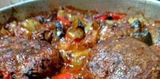 ζουμερά μπιφτέκια ανάμεσα σε ψητά λαχανικά στο ταψί.