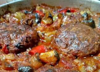 ζουμερά μπιφτέκια ανάμεσα σε ψητά λαχανικά στο ταψί.