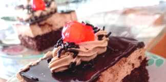 Ένα κομμάτι παστούλας ταψιού με στρώσεις παντεσπανιού σοκολάτας, κρέμας και γλάσου σοκολάτας.