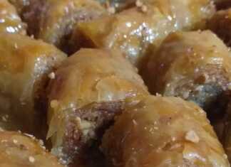 Μια πιατέλα γεμάτη με χρυσαφένια, σιροπιαστά μπακλαβαδάκια, πασπαλισμένα με τριμμένα φιστίκια.