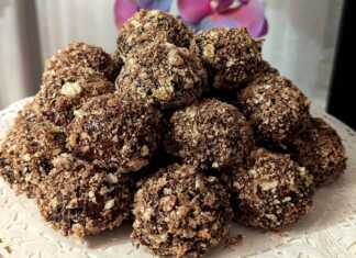 Μια πιατέλα γεμάτη μικρά, στρογγυλά μπισκότα καλυμμένα με σκούρο γλάσο σοκολάτας και τριμμένη ανοιχτόχρωμη γκοφρέτα.