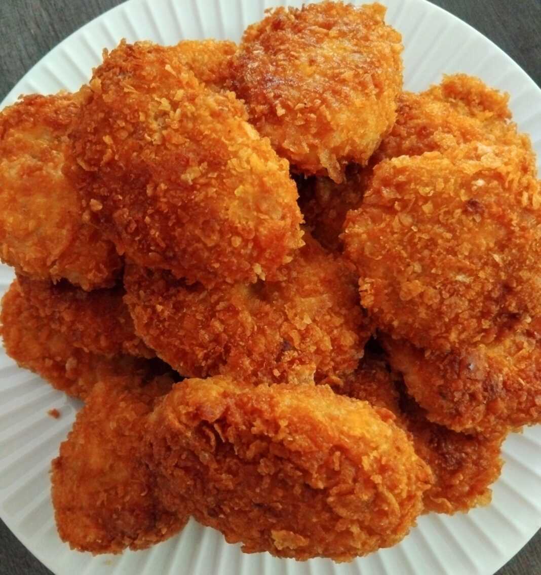 NAUGGETS Χρυσαφένια, τραγανά σπιτικά chicken nuggets σε ένα πιάτο, έτοιμα για σερβίρισμα με διάφορες σος.