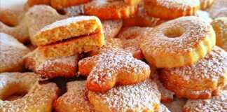 Ένα πιάτο γεμάτο με , χρυσαφένια μπισκότα με ελαφρύ άρωμα πορτοκαλιού, έτοιμα για σερβίρισμα.