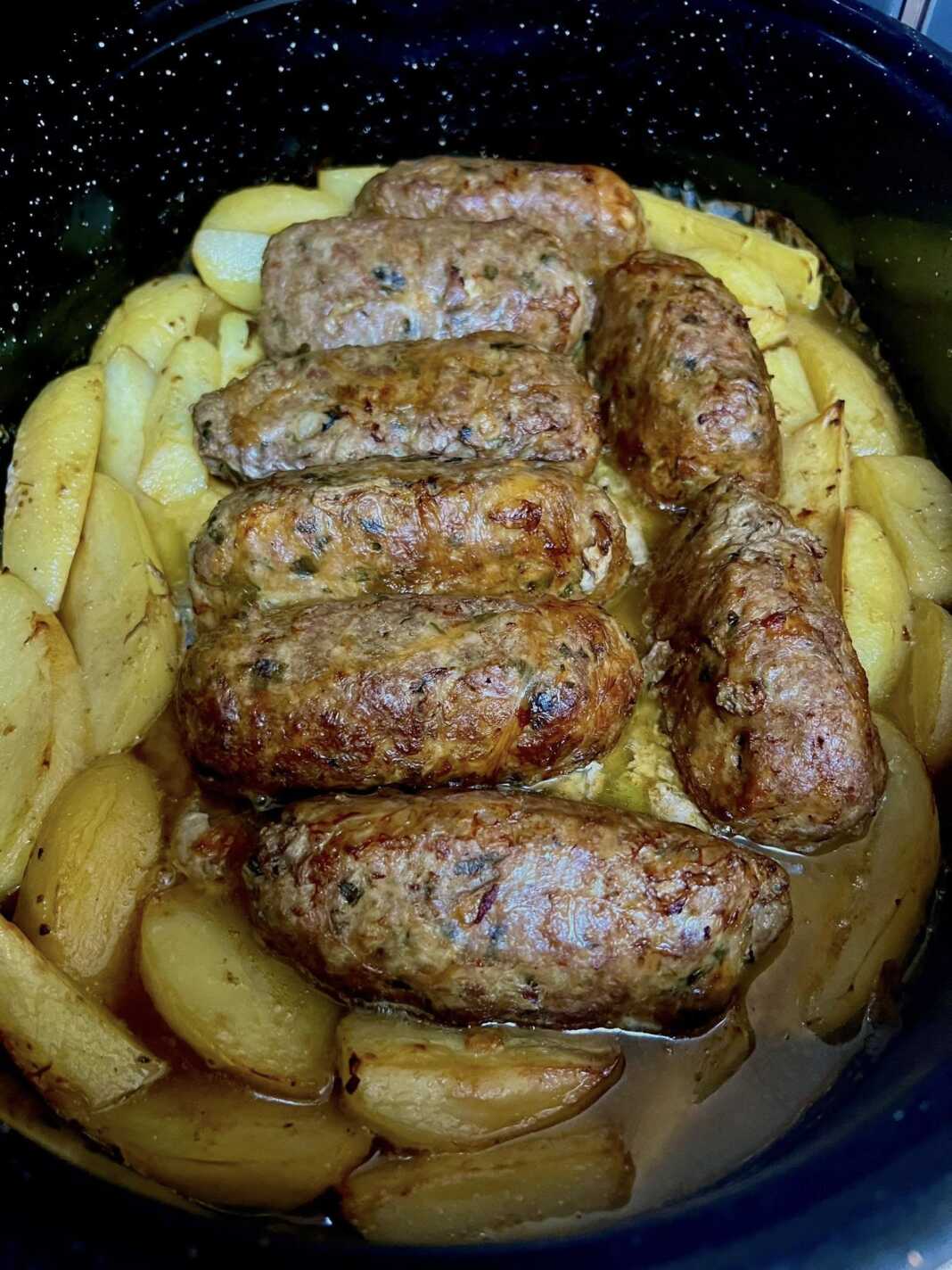 atomika rola me patates Ένα ταψί φούρνου γεμάτο με χρυσαφένια, ψημένα ρολάκια κιμά και κομμάτια πατάτας.