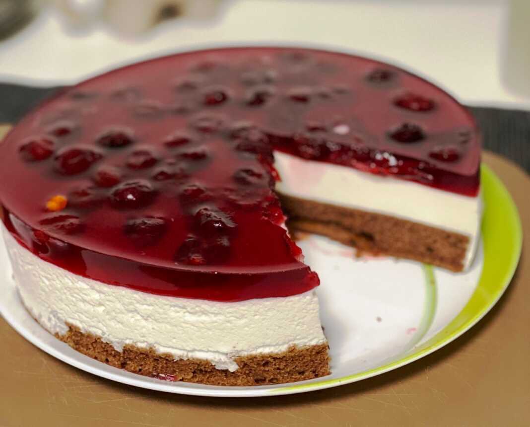 cheese keik kerasia0 Μία τούρτα από πολύστρωτο cheese κέικ με βάση σοκολατένιου παντεσπανι λευκή κρεμώδη μους τυριού και κόκκινη στρώση ζελέ με ολόκληρα κεράσια.