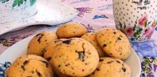 Ένα πιάτο γεμάτο στρογγυλά, χρυσαφένια cookies με κομματάκια σοκολάτας.