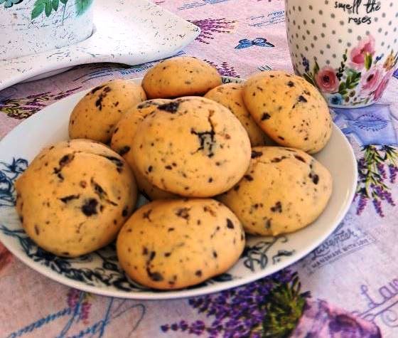cookies sokolata portokali Ένα πιάτο γεμάτο στρογγυλά, χρυσαφένια cookies με κομματάκια σοκολάτας.
