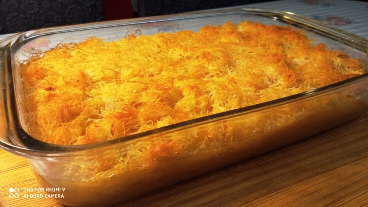 Ένα ολόκληρο γαλακτομπούρεκο με φύλλο κανταΐφι σε ένα πυρέξ ταψί, με χρυσαφένια, τραγανή επιφάνεια.