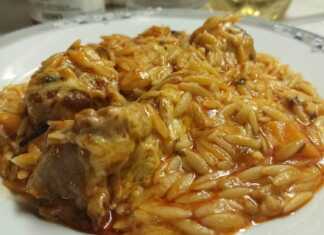 Μια γάστρα γεμάτη με ζεστό γιουβέτσι μοσχαράκι, με κόκκινη σάλτσα, κριθαράκι και λιωμένο τριμμένο τυρί στην επιφάνεια.