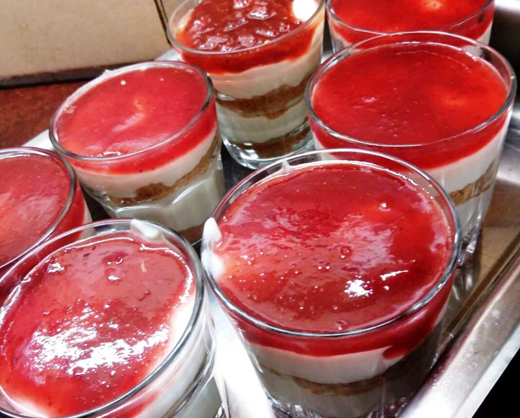 glikaki me fraoula 7 γυάλινα μπολακια με στρώσεις από τριμμένα μπισκότα, λευκή κρέμα γιαουρτιού και κόκκινη μαρμελάδα φράουλα στην κορυφή.