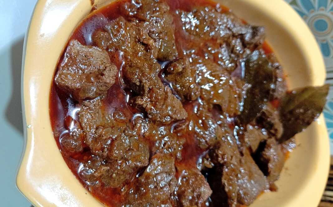 Ένα πιάτο με πλούσιο, κόκκινο μοσχαρίσιο γκούλας και κομμάτια κρέατος