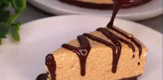 Ένα κομμάτι δροσερό τσιζκέικ με βάση μπισκότου και κρεμώδη λευκή στρώση, διακοσμημένο με λίγη σάλτσα καραμέλας, σερβιρισμένο σε ένα πιάτο.