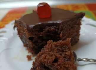 Ένα τετράγωνο κομμάτι από λαχταριστή, σιροπιασμένη καρυδόπιτα με καρύδια, καλυμμένη με ένα γυαλιστερό, σκούρο σοκολατένιο γλάσο.