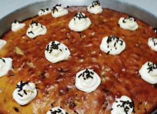 Ένα ταψί καρυδόπιτας με τρούφα, περιχυμένο με σιρόπι. Φαίνεται η αφράτη υφή του κέικ και τα κομμάτια καρυδιού.