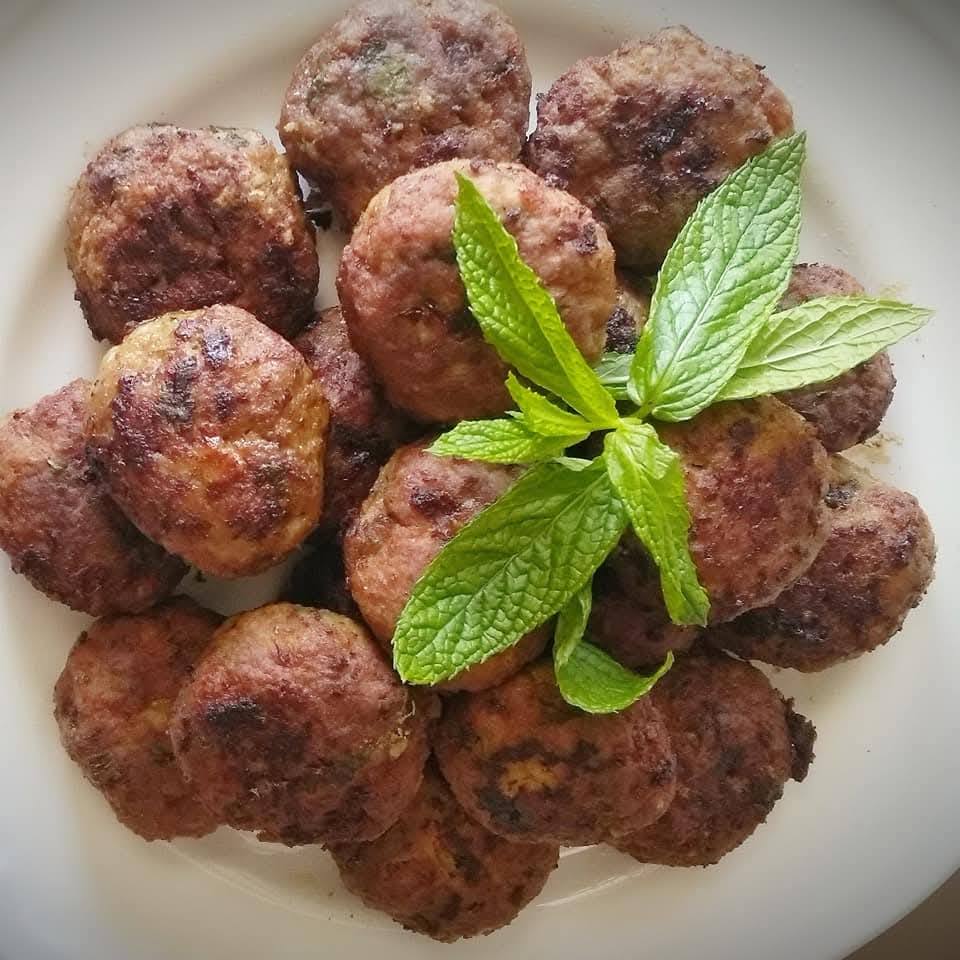 keftedes mosxobolane Μια πιατέλα γεμάτη χρυσαφένιους, τηγανισμένους κεφτέδες, με ψιλοκομμένο μαϊντανό από πάνω, έτοιμοι για σερβίρισμα.