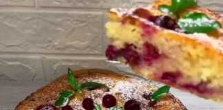 Ένα αφράτο κέικ με κεράσια, κομμένο, που φαίνεται η ροδοκόκκινη κρούστα και η ζουμερή σάρκα με τα κομμάτια κερασιού.