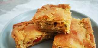 Μια φρεσκοψημένη, χρυσαφένια κιμαδόπιτα κοτόπουλου, κομμένη σε τετράγωνα κομμάτια, που αναδεικνύει τις στρώσεις του τραγανού φύλλου.