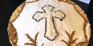 Ένα πιάτο με στολισμένα κόλλυβα, καλυμμένα με ζάχαρη άχνη και διακοσμημένα με σταυρό από τριμμένη καρύδα, κανέλα και βρώσιμες πέρλες.