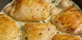 Μαγειρεμένα μπούτια κοτόπουλου σε ένα τηγάνι, καλυμμένα με μια πηχτή, κρεμώδη σάλτσα σκόρδου και πασπαλισμένα με φρέσκο μαϊντανό.