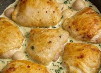 Μαγειρεμένα μπούτια κοτόπουλου σε ένα τηγάνι, καλυμμένα με μια πηχτή, κρεμώδη σάλτσα σκόρδου και πασπαλισμένα με φρέσκο μαϊντανό.