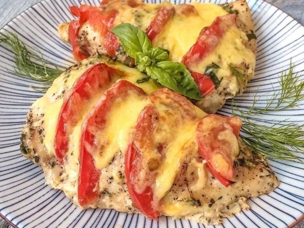 Δυο φιλέτα κοτόπουλο με ντομάτα και τυρι λιωμενο και μυρωδικα μολις εχει ψηθεί