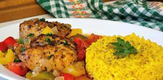 Πιάτο με ζουμερό κοτόπουλο με πιπεριές σε κόκκινη σάλτσα και αρωματικό ρύζι με σαφράν.