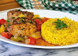 Πιάτο με ζουμερό κοτόπουλο με πιπεριές σε κόκκινη σάλτσα και αρωματικό ρύζι με σαφράν.