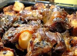 Ένα βαθύ ταψί γεμάτο με χρυσαφένια ψημένη προβατίνα και κομμάτια ψωμιού (μπούκες) που έχουν απορροφήσει τους ζωμούς, έτοιμο για σερβίρισμα.